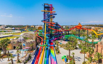 Colorful water slides at The Land of Legends Theme Park, Turkey, with lush surroundings.