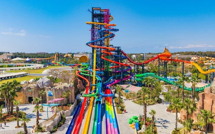 Colorful water slides at The Land of Legends Theme Park, Turkey, with lush surroundings.