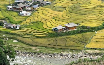 Sapa rice terraces with village homes and river, Vietnam trekking tour.