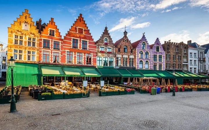 Colorful gabled buildings in Bruges market square, part of self-guided walking tour.