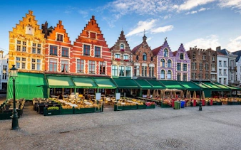Colorful gabled buildings in Bruges market square, part of self-guided walking tour.