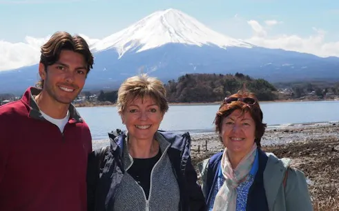 Tourists with Mount Fuji backdrop on Tokyo museums tour.