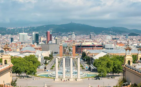 Barcelona cityscape view from Montjuïc, featuring Magic Fountain and surrounding architecture.