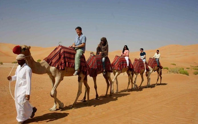 Camel ride through desert dunes during Hurghada safari tour.