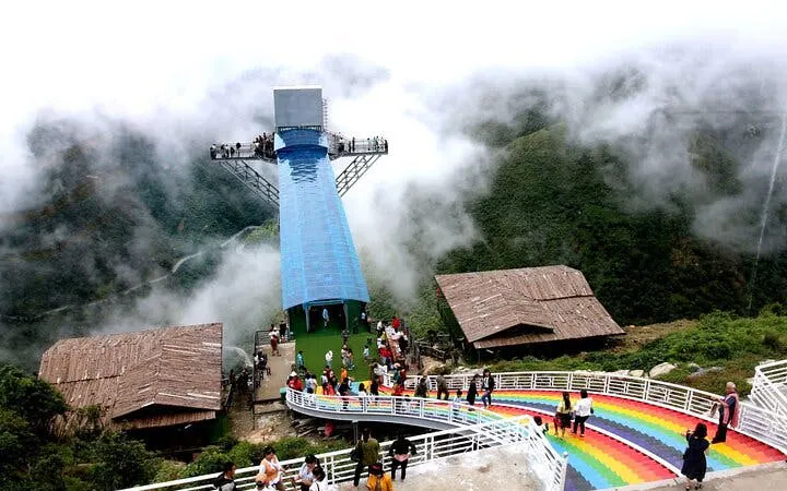 Glass bridge with visitors at Heaven Gate, surrounded by misty mountains, part of Silver Waterfall tour.