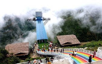 Glass bridge with visitors at Heaven Gate, surrounded by misty mountains, part of Silver Waterfall tour.