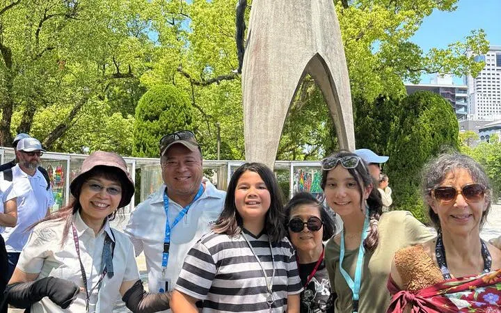 Group of tourists at Hiroshima Peace Memorial Park near the Children's Peace Monument.