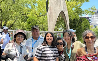 Group of tourists at Hiroshima Peace Memorial Park near the Children's Peace Monument.