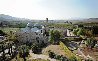 Ancient stone building in Ephesus surrounded by greenery, part of a 2-day tour from Istanbul.