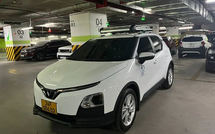 White car in parking garage for private transfer from Sapa to Lào Cai Train Station.