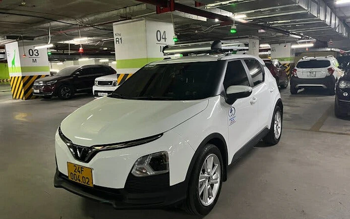 White car in parking garage for private transfer from Sapa to Lào Cai Train Station.