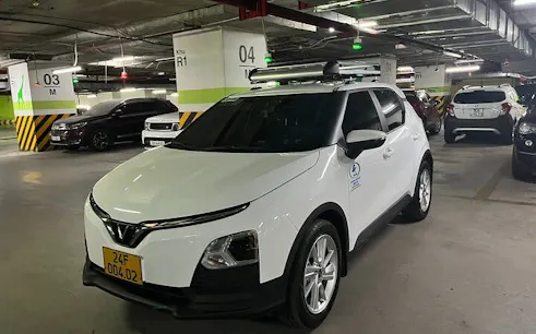 White car in parking garage for private transfer from Sapa to Lào Cai Train Station.