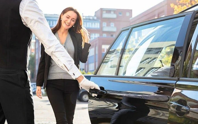 Driver opening car door for passenger, personalized airport transfer service, Hurghada hotel.