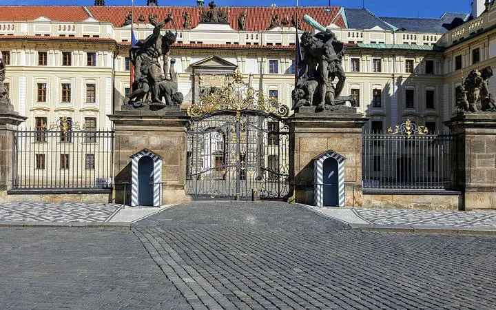 Prague Castle entrance with ornate gates and statues, part of Gothic city exploration game.
