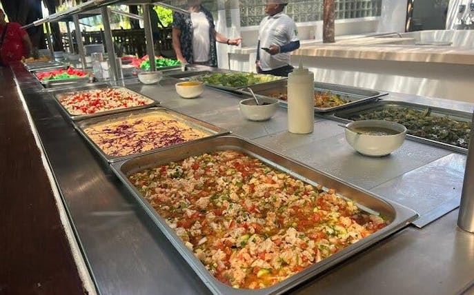 Buffet with fresh salads and dishes at Isla Mujeres beach club during catamaran tour.