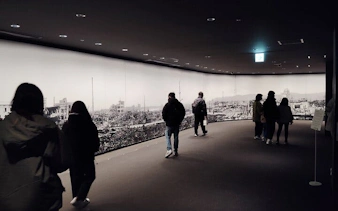 Visitors viewing Hiroshima Peace Memorial Museum exhibit.