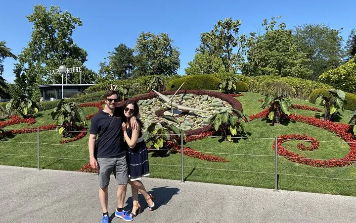 Couple in front of Geneva's L'Horloge Fleurie, part of self-guided city exploration game.