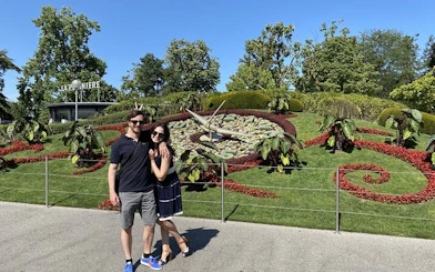 Couple in front of Geneva's L'Horloge Fleurie, part of self-guided city exploration game.