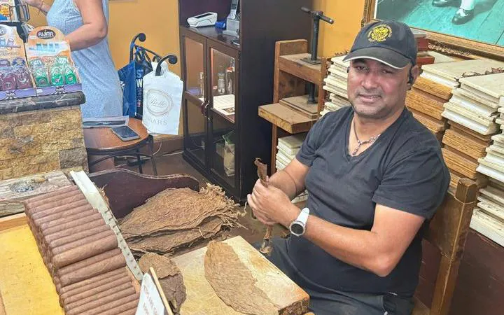 Cigar maker rolling cigars at a shop on Calle Ocho, Little Havana, Miami.