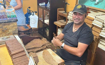 Cigar maker rolling cigars at a shop on Calle Ocho, Little Havana, Miami.