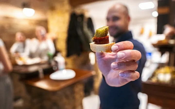Man holding appetizer during Budapest food tour with local guide.