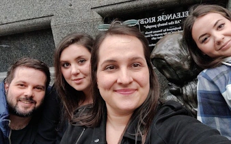 Group exploring haunted Liverpool statue during self-guided city game.