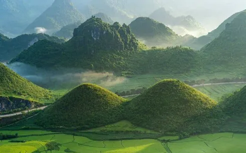 Ha Giang lush green hills and winding roads on motorbike loop tour, Vietnam.