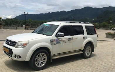 Private transfer vehicle for Sapa to Lào Cai Train Station with mountain backdrop.