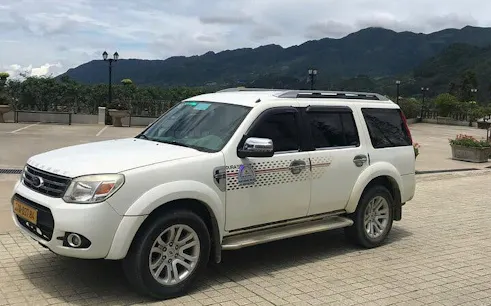 Private transfer vehicle for Sapa to Lào Cai Train Station with mountain backdrop.