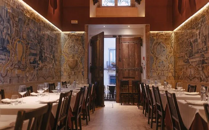 Dining tables set for a Portuguese dinner at Mesa de Frades Chapel, Lisbon, with traditional azulejos.