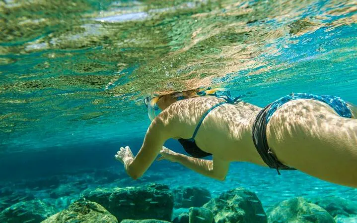 Snorkeler exploring clear waters over coral reefs at Tiran Island, Sharm El Sheikh.