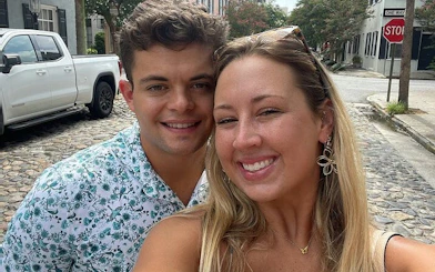 Couple smiling on a cobblestone street in historic Charleston during a self-guided city exploration game.