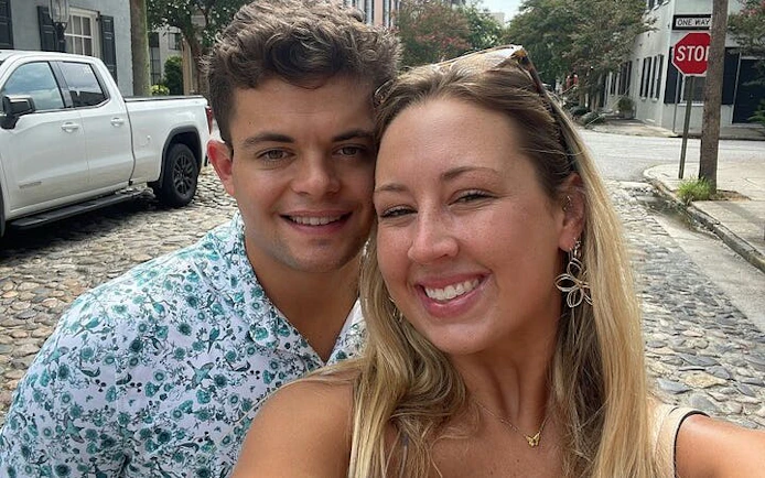 Couple smiling on a cobblestone street in historic Charleston during a self-guided city exploration game.
