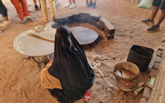 Bedouin woman preparing traditional bread in Sharm El Sheikh desert village.