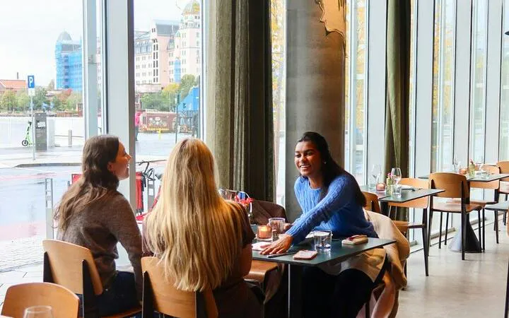 Group dining at a restaurant in Oslo with a view of the waterfront.