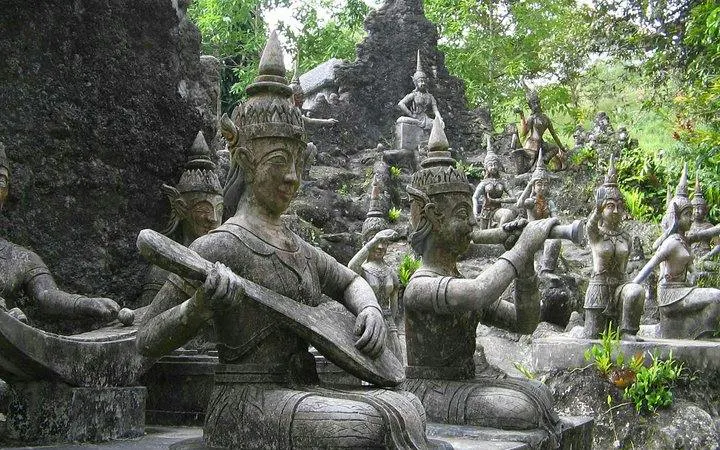 Ancient stone statues of musicians in a lush garden on Koh Samui 4WD Jeep Safari Tour.
