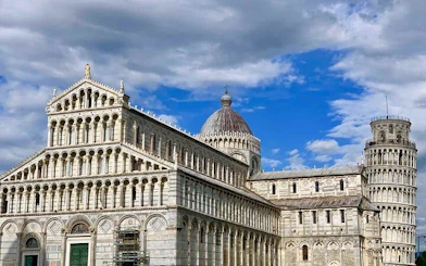 Pisa Cathedral and Leaning Tower under a blue sky, Italy.