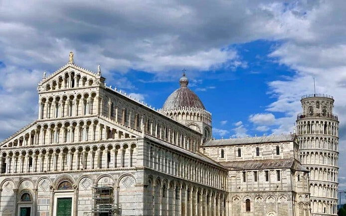 Pisa Cathedral and Leaning Tower under a blue sky, Italy.