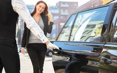 Driver opening car door for passenger during Sharm Airport transfer to Sharm El Sheikh hotel.