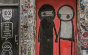 Street art mural on Brick Lane featuring two abstract figures.