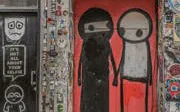 Street art mural on Brick Lane featuring two abstract figures.