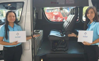 Phuket airport minivan transfer with staff showing vehicle interior for Khao Lak and Phang Nga hotels.