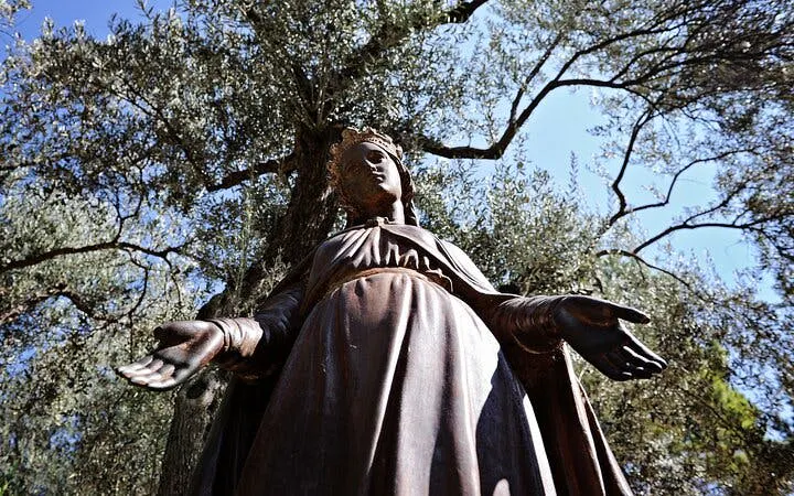 Statue of the Virgin Mary surrounded by olive trees in Ephesus, Turkey.