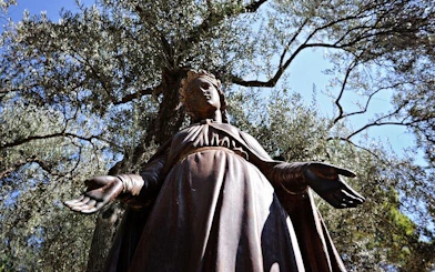 Statue of the Virgin Mary surrounded by olive trees in Ephesus, Turkey.