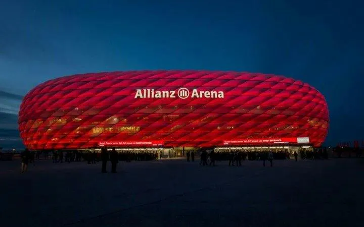 Allianz Arena illuminated at night, Munich, part of Vienna to Munich transfer tour.