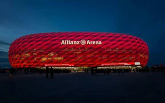 Allianz Arena illuminated at night, Munich, part of Vienna to Munich transfer tour.