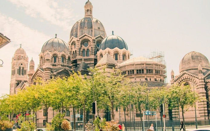 Marseille Cathedral with trees in foreground on self-guided walking tour.