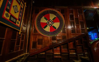 Traditional tapestry on wooden wall inside Sapa museum during cultural tour.