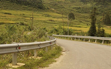Winding road through lush green hills in Sapa, Vietnam, part of a motorbike tour.