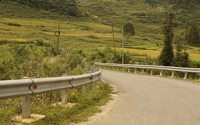 Winding road through lush green hills in Sapa, Vietnam, part of a motorbike tour.